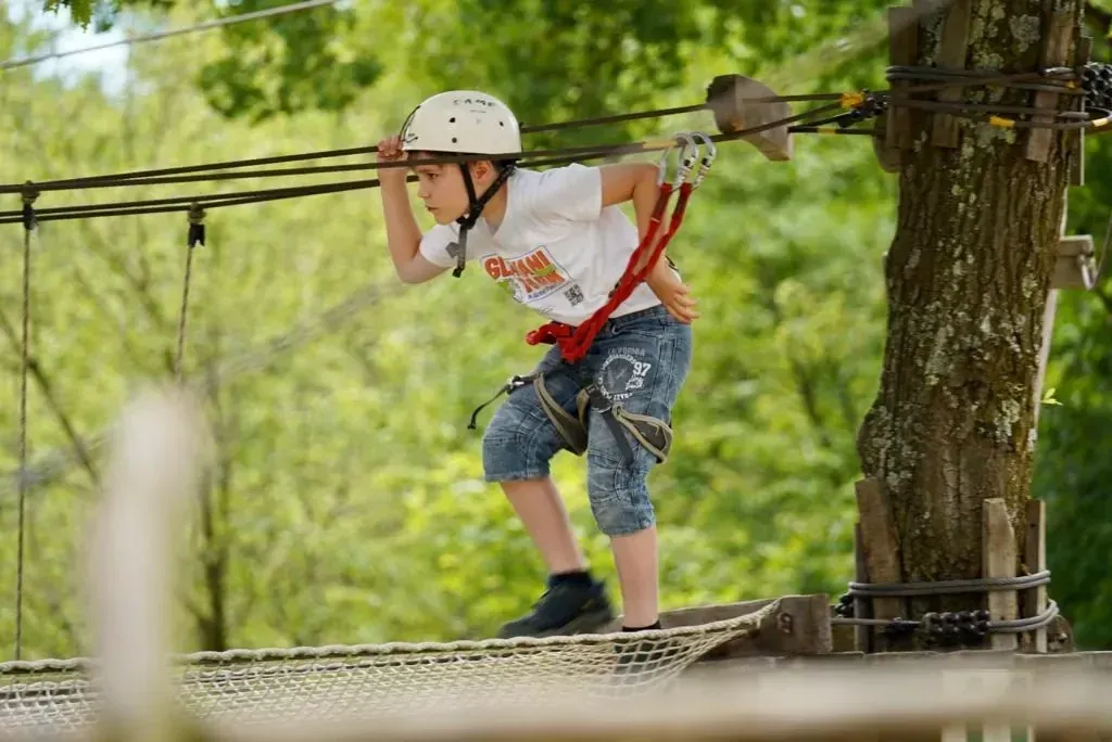 Guest crossing a treetop obstacle at Glavani Park, Istria